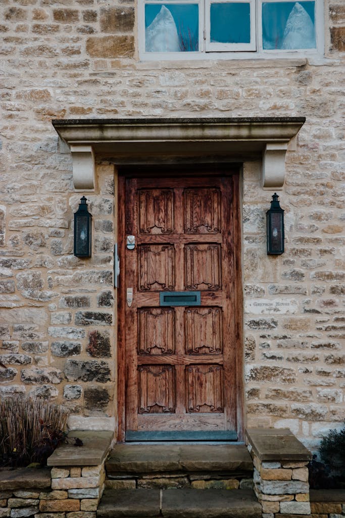 Charming entrance of an old stone house featuring a rustic wooden door.